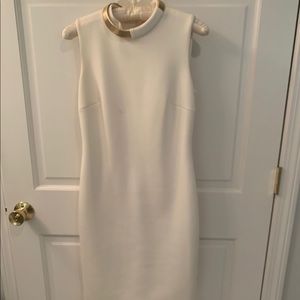 White sleeveless dress with gold detail on neck